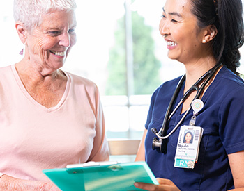 A care provider discussing a chart with an older patient.